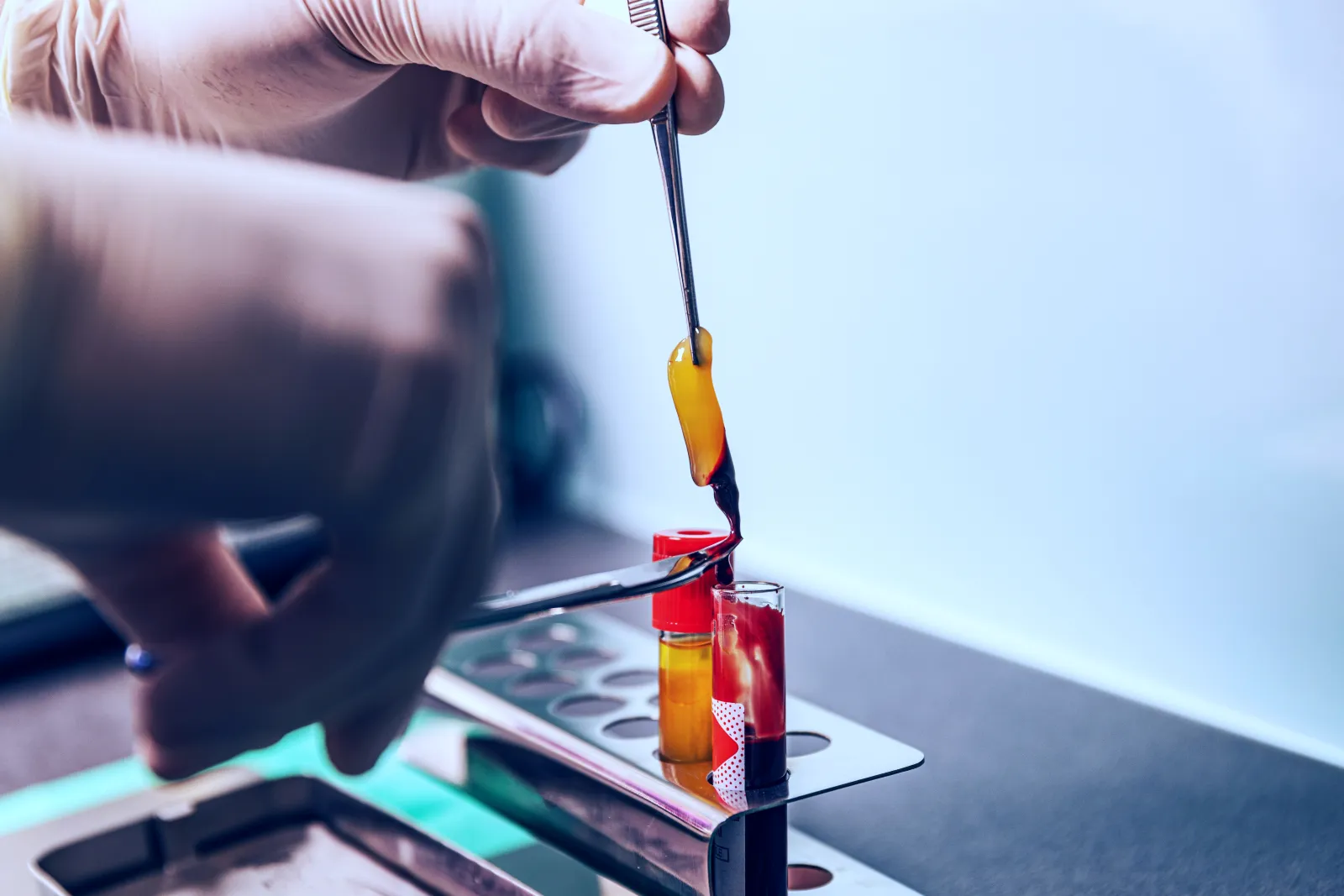 A person holding a pair of scissors cutting a piece of glass.